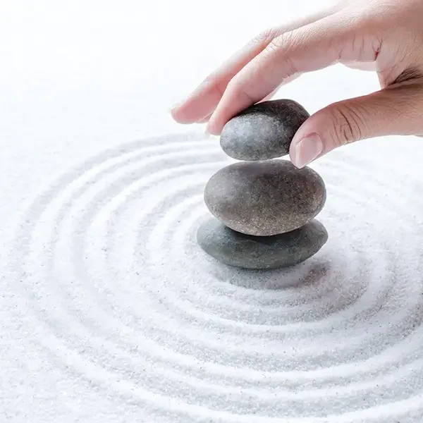 mano-apilamiento-piedras-zen-arena-fondo-bienestar copia